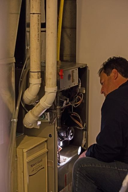 Home inspector examining furnace and heating system