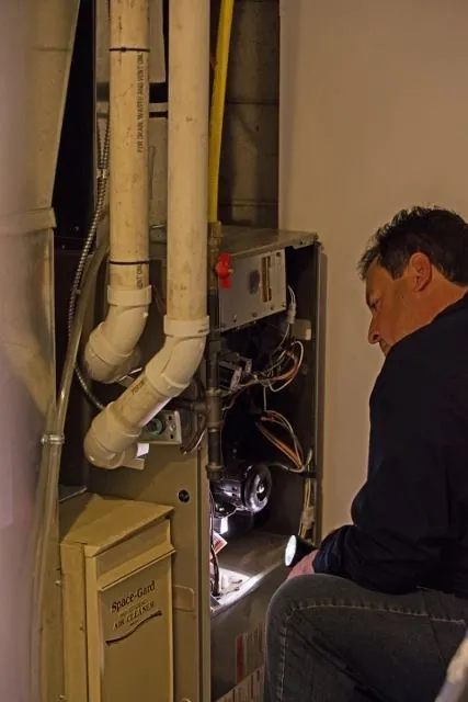 Home inspector examining furnace and heating system
